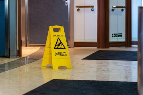Clean commercial lobby with a wet-floor sign during cleaning